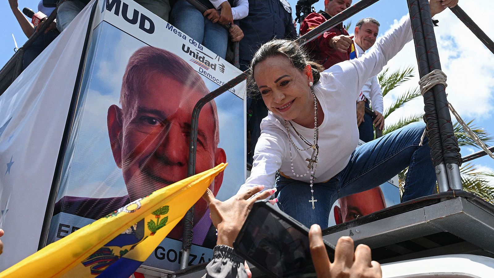 La líder antichavista María Corina Machado junto a un cartel con la imagen del abanderado de la oposición mayoritaria, Edmundo González Urrutia