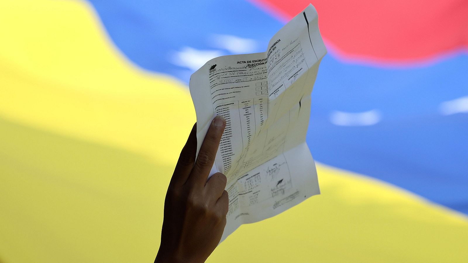 Un persona sostiene una copia de un acta de votación durante una manifestación en rechazo a los resultados del Consejo Nacional Electoral venezolano