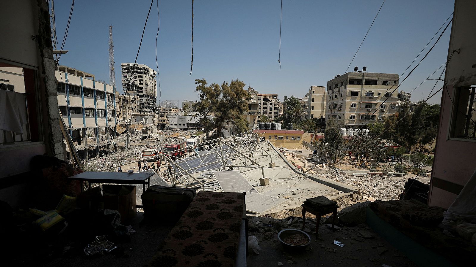 Los palestinos inspeccionan una escuela que alberga a personas desplazadas después de un ataque israelí