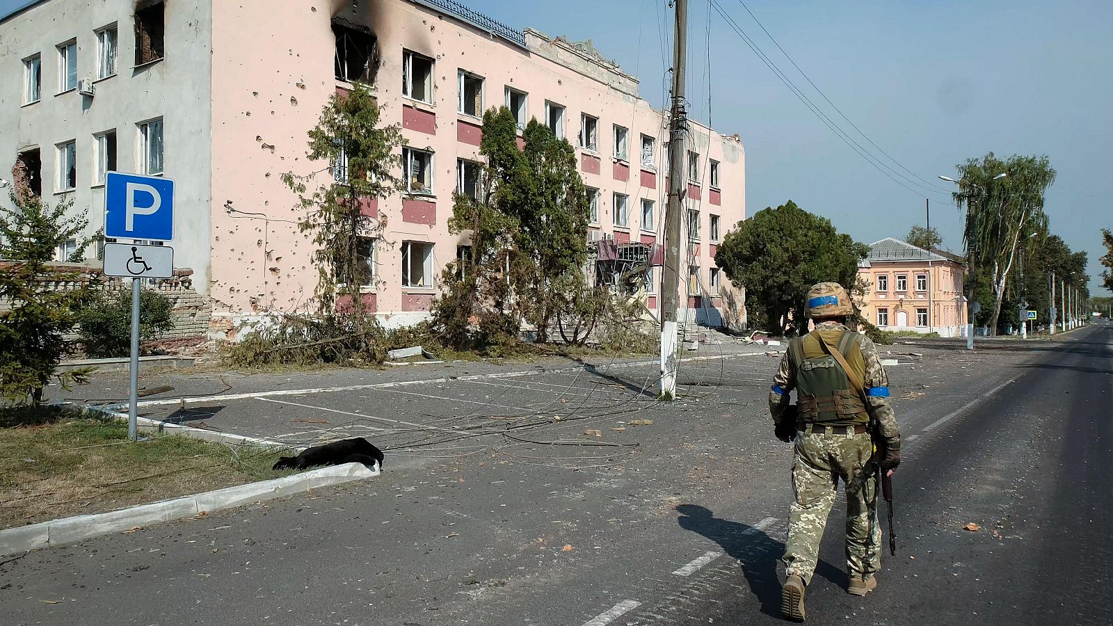 Un militar ucraniano camina cerca de edificios dañados en el centro de la ciudad de Sudzha, Kursk