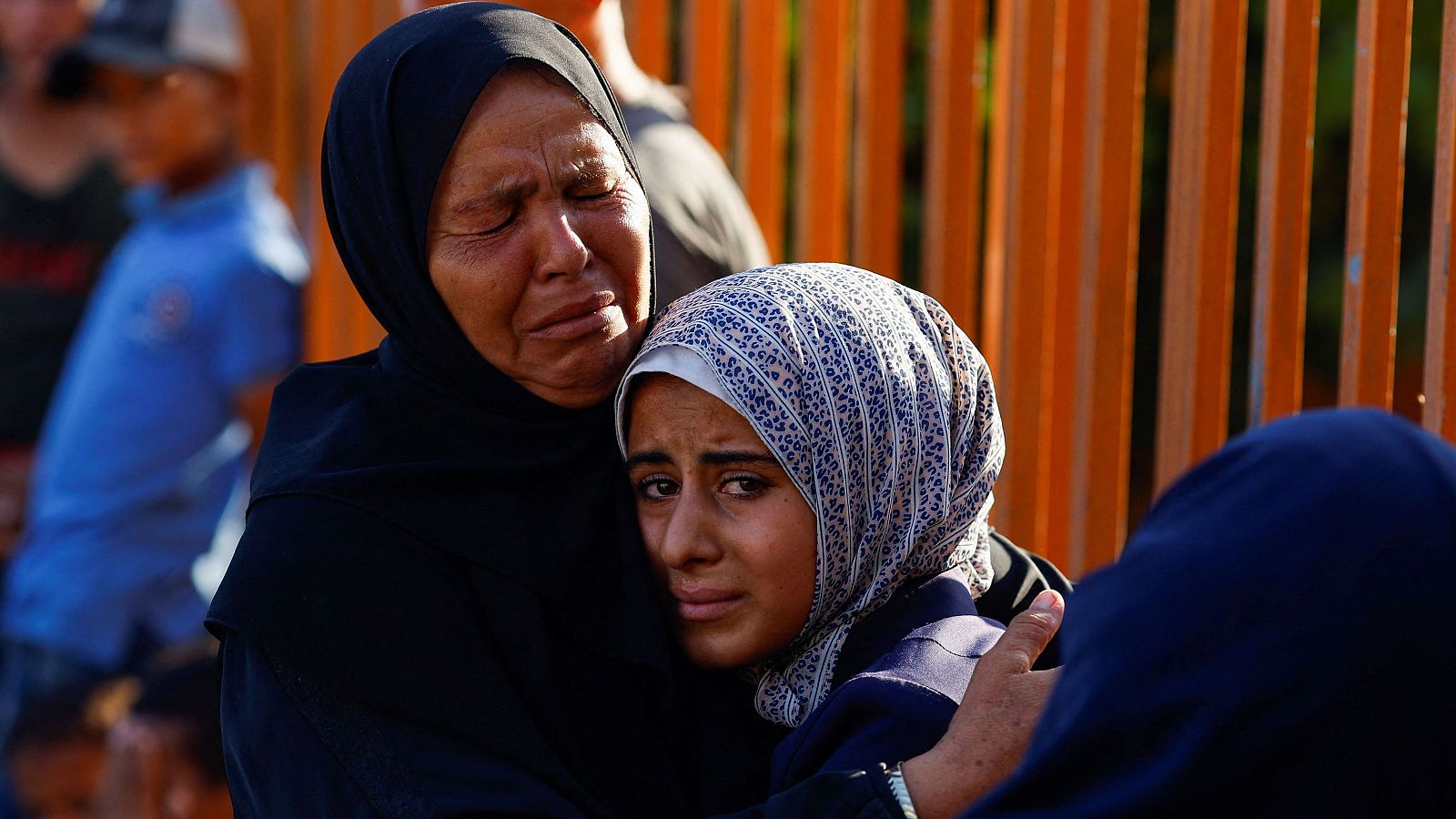 Dos mujeres se abrazan durante un funeral de los palestinos muertos en ataques israelíes en Jan Yunis