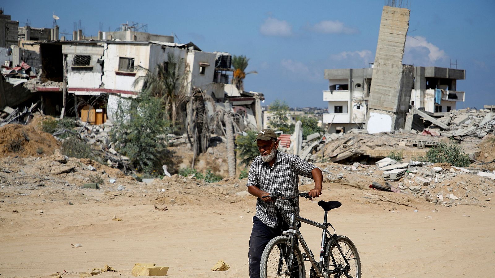 Un palestino camina con una bicicleta en Jan Yunis, después de que las fuerzas israelíes se retiraran de la zona. Israel mantendrá sus tropas en la frontera gazatí con Egipto y dice haber matado a un líder de Hamás en Yenín.