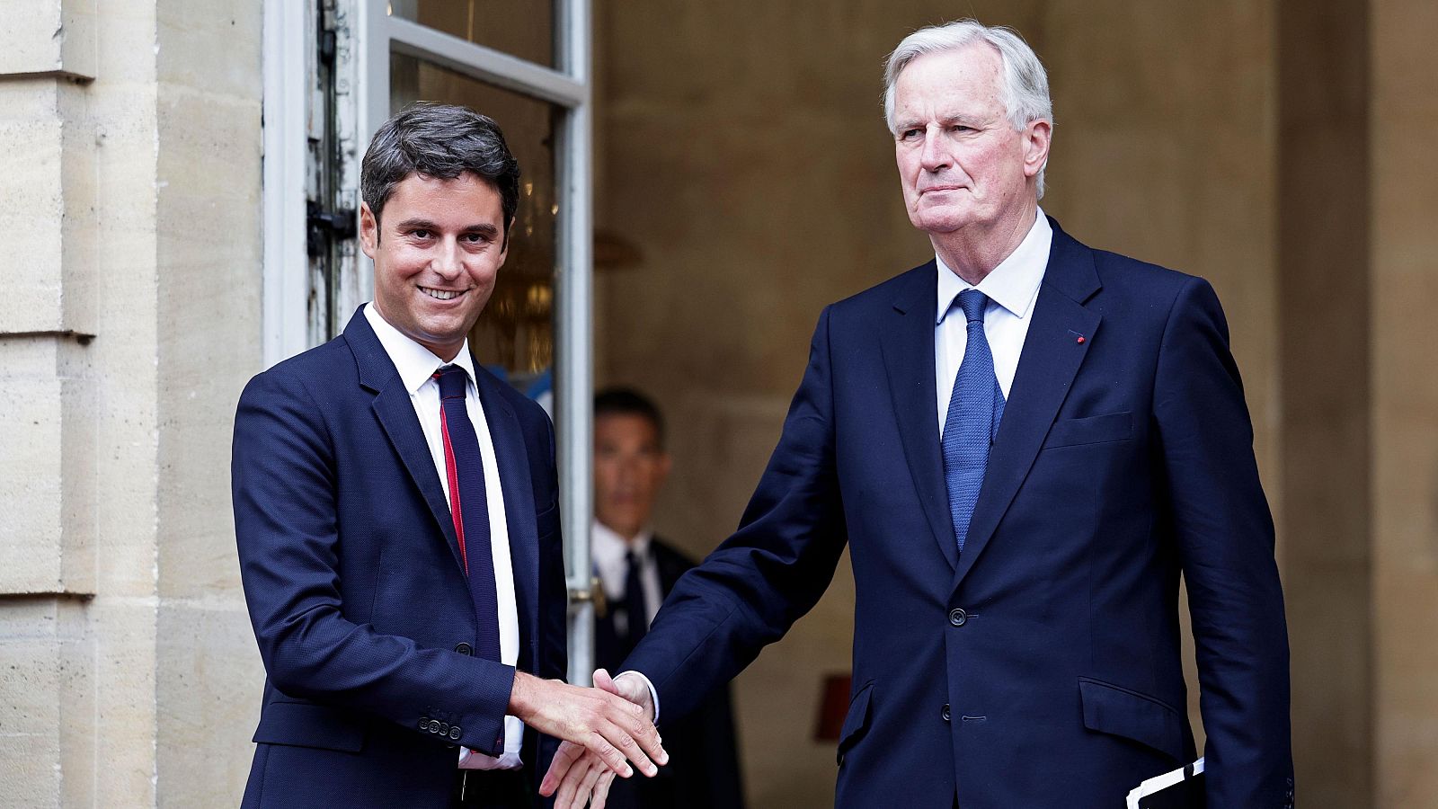 El recién nombrado primer ministro de Francia, Michel Barnier, estrecha la mano del primer ministro saliente, Gabriel Attal