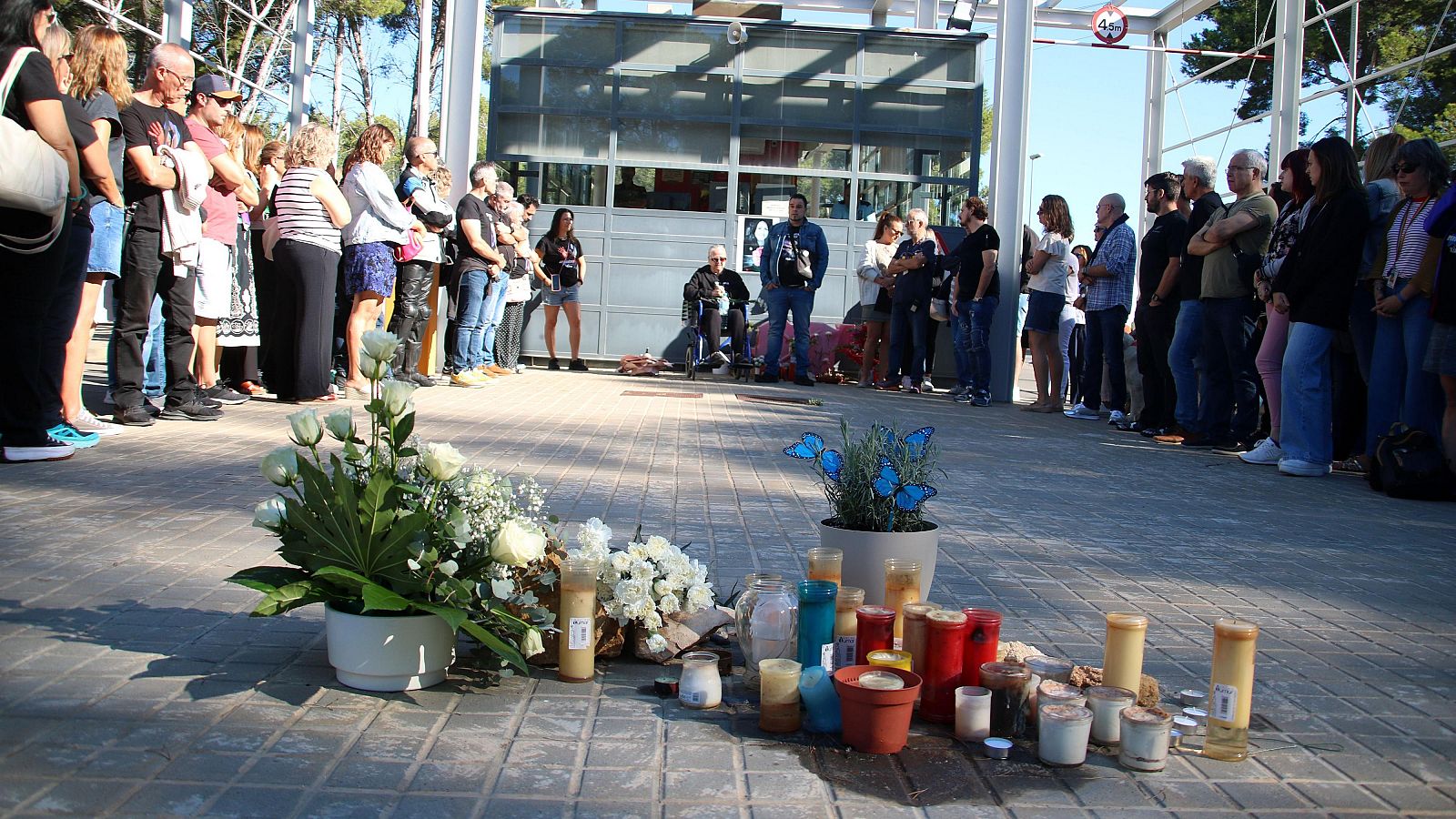 Funcionaris de presons, familiars i amics fan cinc minuts de silenci i dipositen flors a l'entrada de Mas d'Enric.