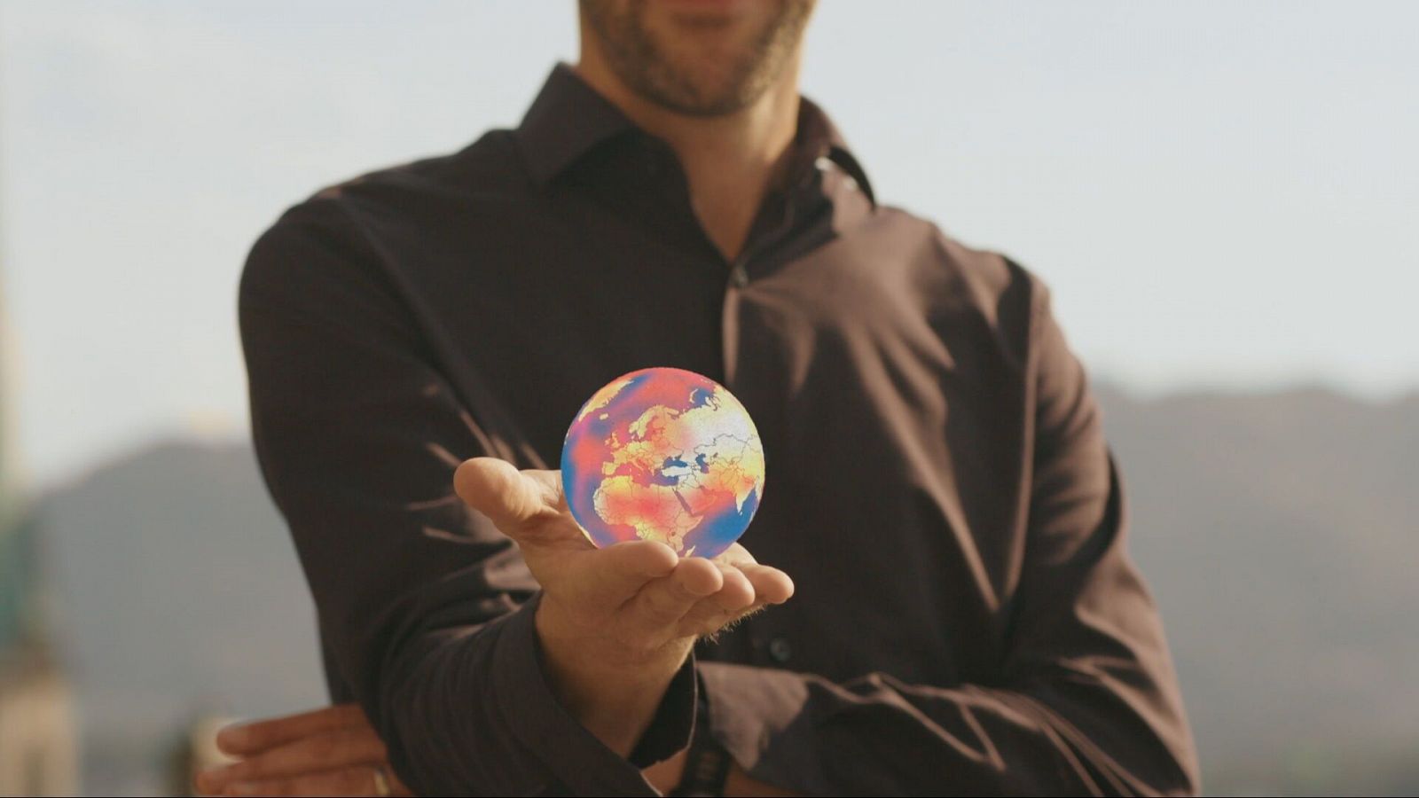 manos sujetan un globo terráqueo con olas de calor