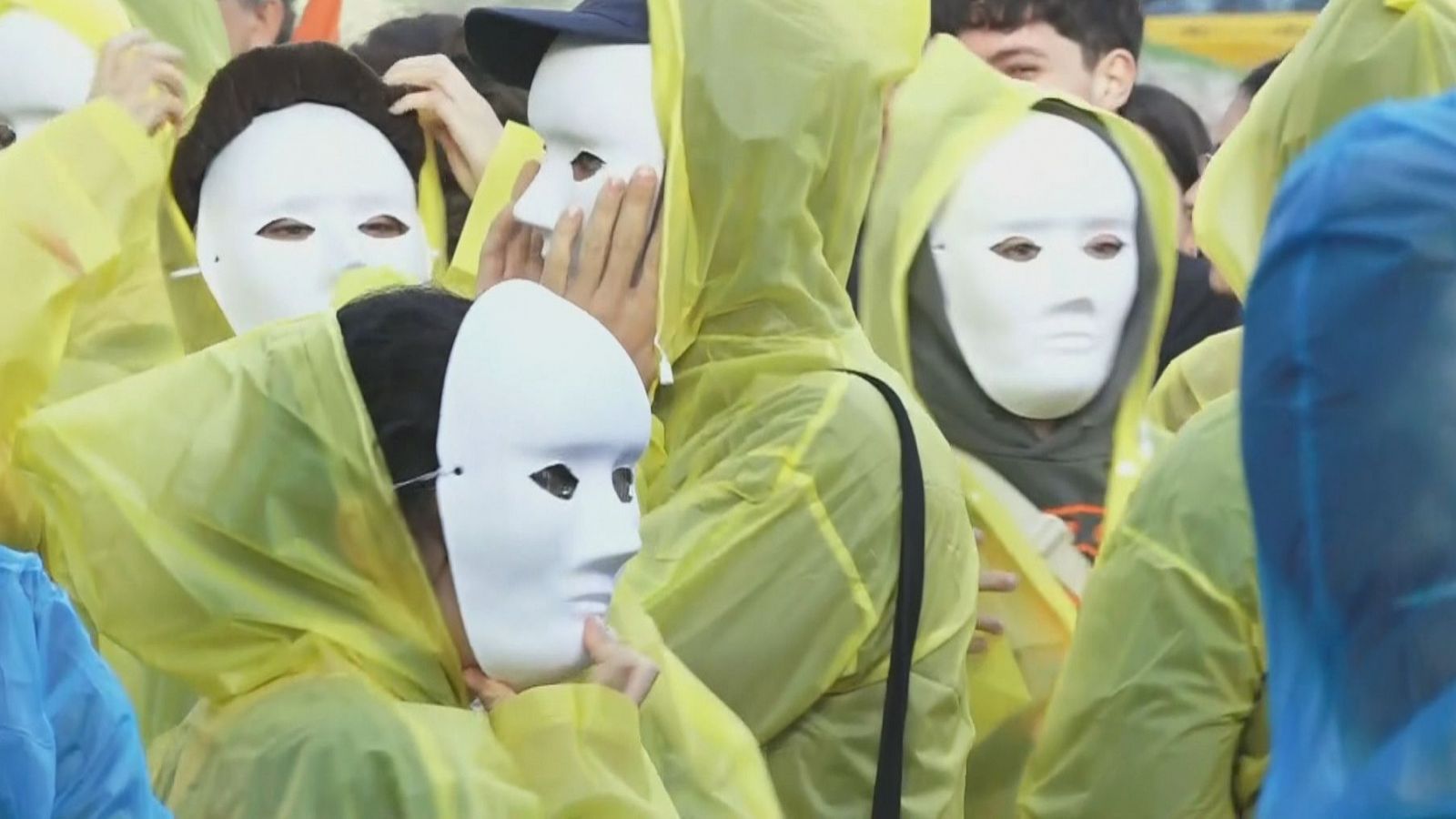 Un grup de manifestants de la protesta contra The Distric amb mascares i impermeables