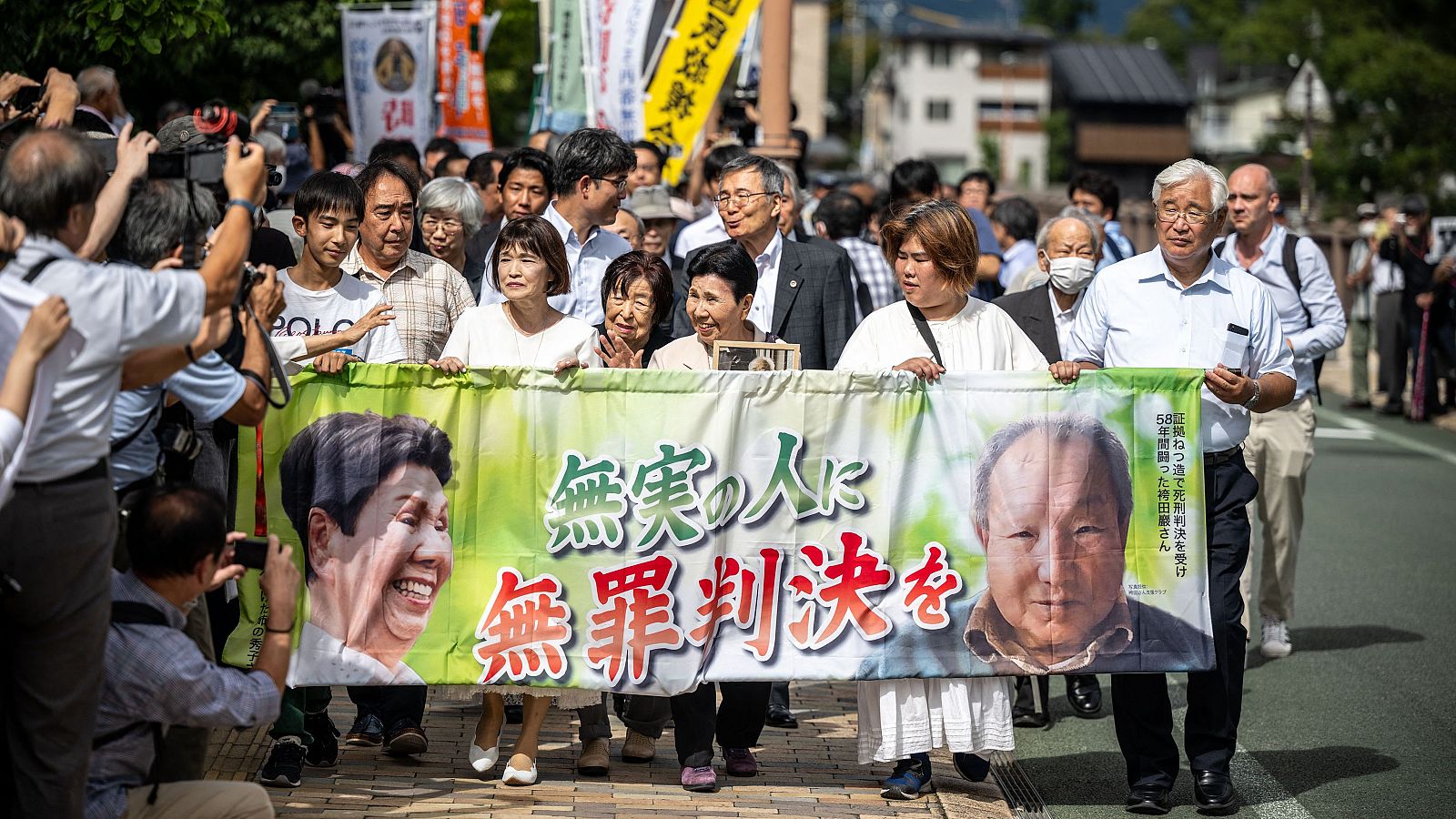 Hideko Hakamada (C) sostiene un retrato y una pancarta en la que se lee "hombre inocente, veredicto de inocencia" para apoyar a su hermano Iwao Hakamada.