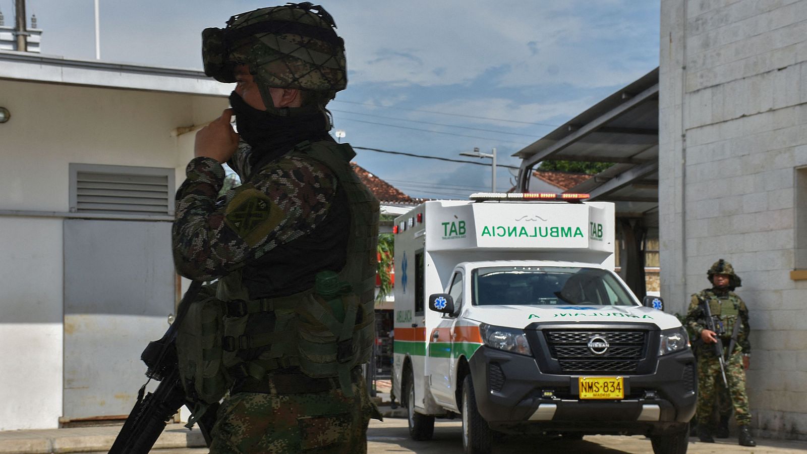 Dos soldados colombianos hacen guardia mientras una ambulancia transporta a un herido en un ataque del ELN en Arauca