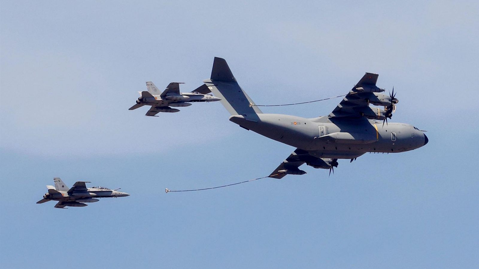 Un avión cisterna Airbus A400 provee de combustible a dos cazabombarderos