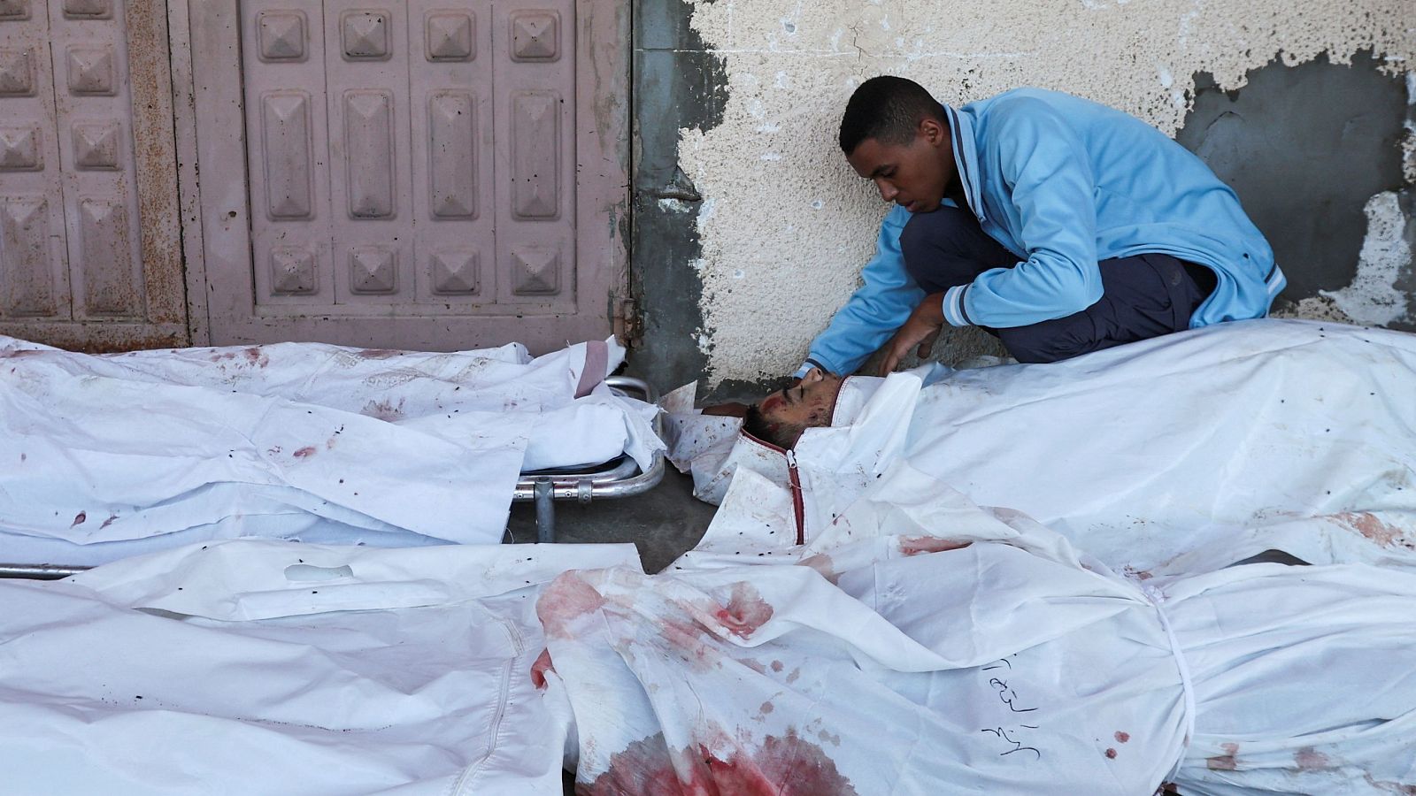 Un joven reacciona junto a los cuerpos de los palestinos que murieron en un ataque israelí