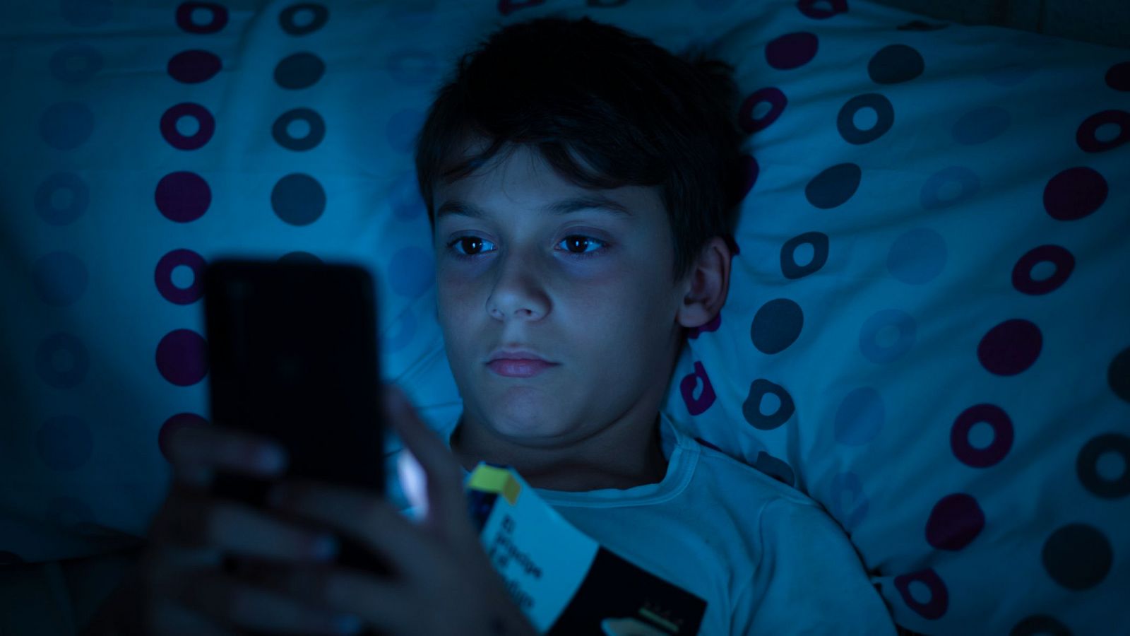 Niño con problemas de sueño e insomnio debido al uso de dispositivos electrónicos