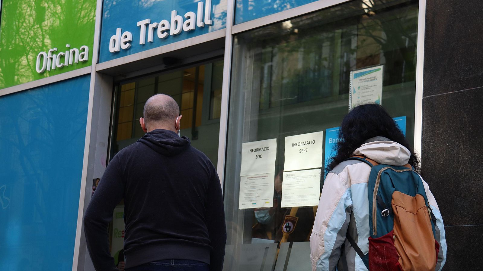 Dues persones esperant per entrar a l'Oficina de Treball a Barcelona (ACN)