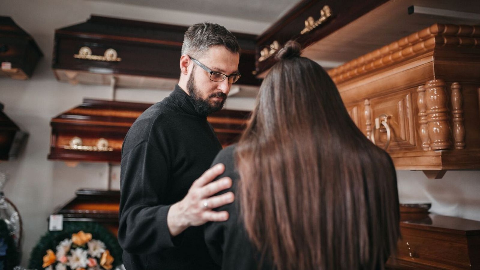 Un treballador d'una funerària consola una clienta.