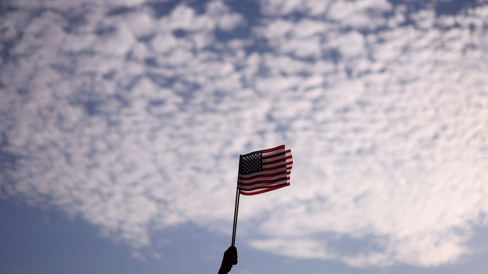 Una persona sostiene una bandera estadounidense en un acto de campaña de la candidata presidencial demócrata Kamala Harris en Washington, Estados Unidos