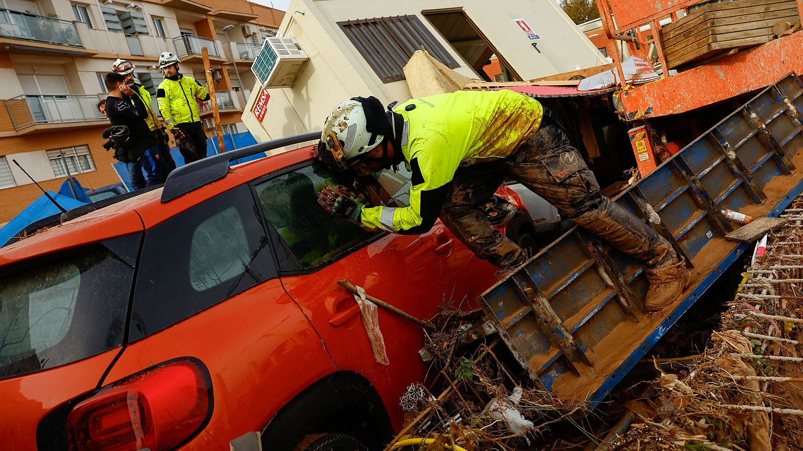 Los servicios de emergencias comprobando si hay cuerpos en el interior de los vehículos apilados.