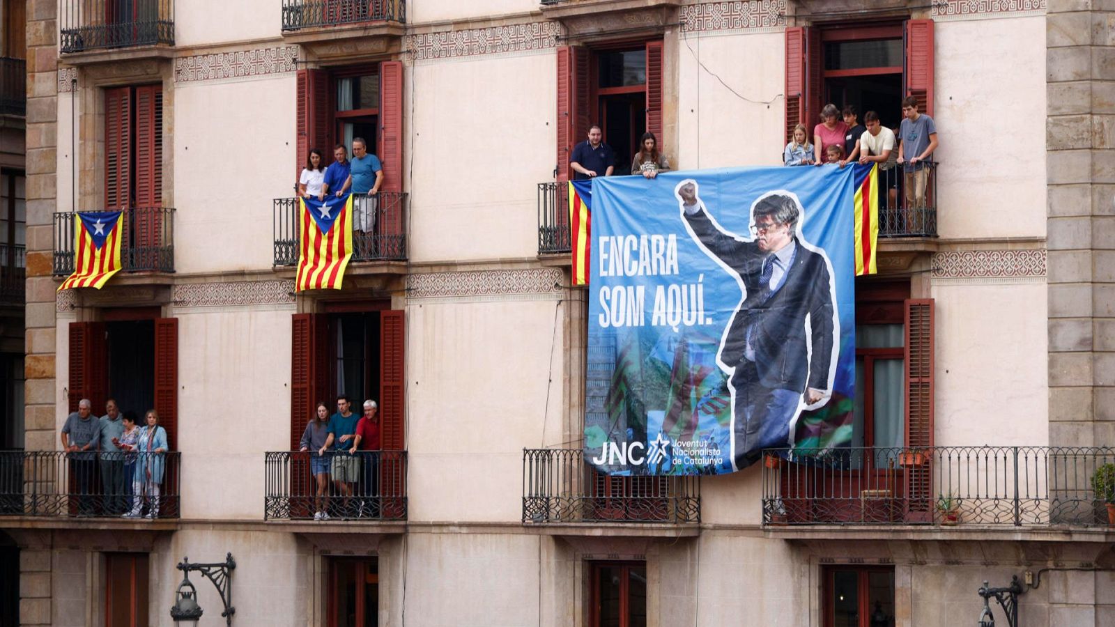 Miembros de las Juventudes Nacionalistas de Cataluña (JNC) cuelgan una pancarta alusiva Carles Puigdemont