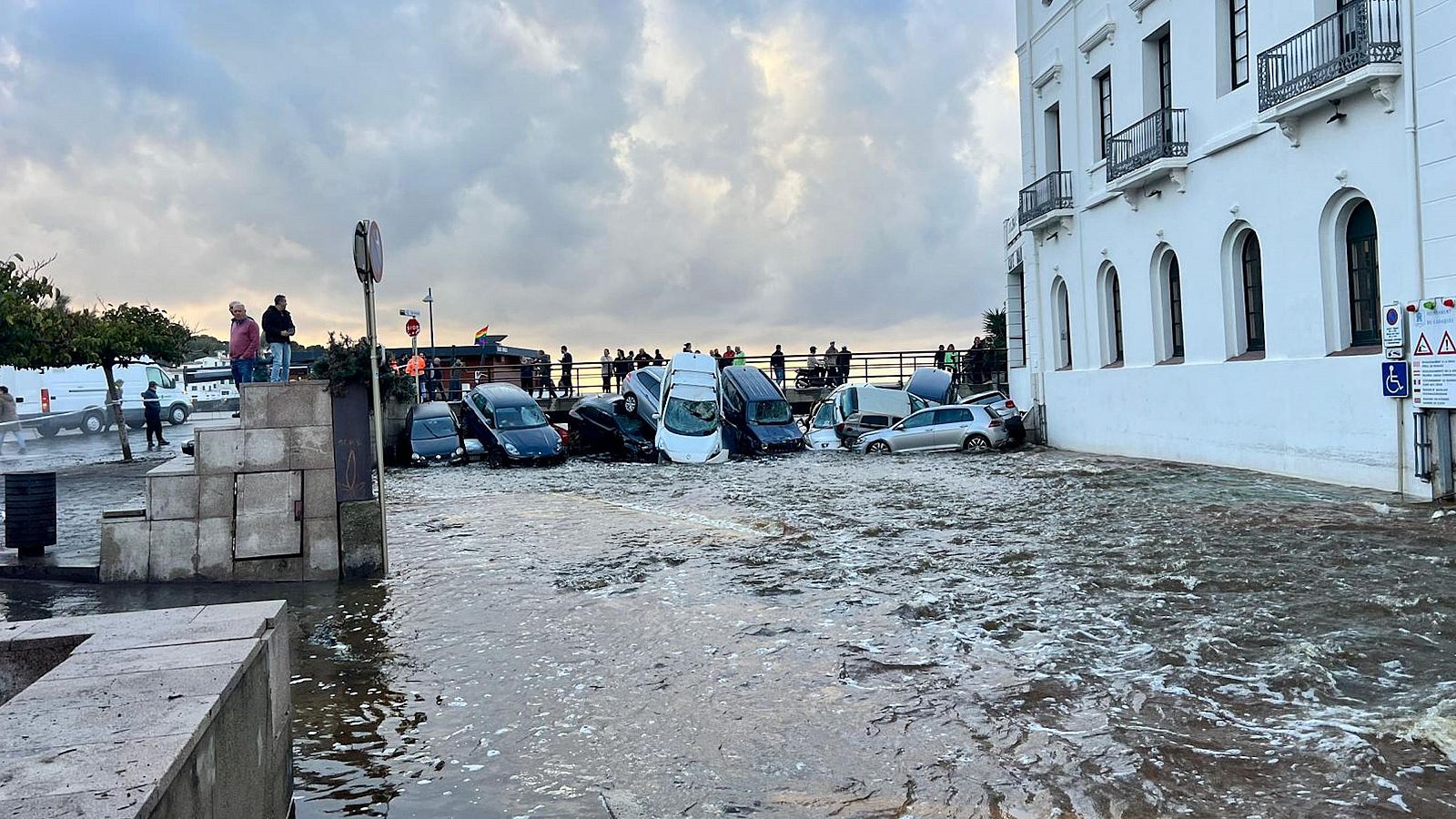 Cotxes arrossegats per la riera a Cadaqués i ciutadans observant els desperfectes (ACN | Gemma Tubert)