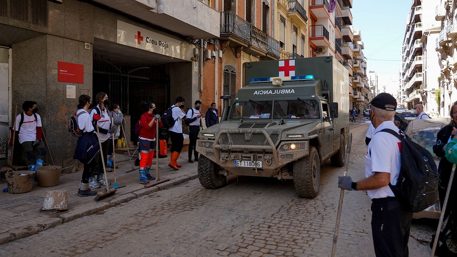 Voluntarios y un vehículo de la UME frente a la Cruz Roja en Algemesí, Valencia, tras el paso de la DANA.