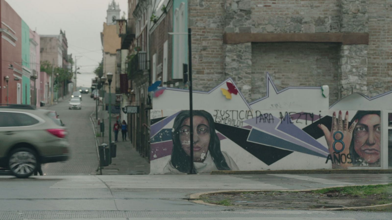 Mural en Puebla con el rostro de una mujer y la frase "Justicia para Meztli Esmeralda", junto a una mano con el número 8 representando los años.