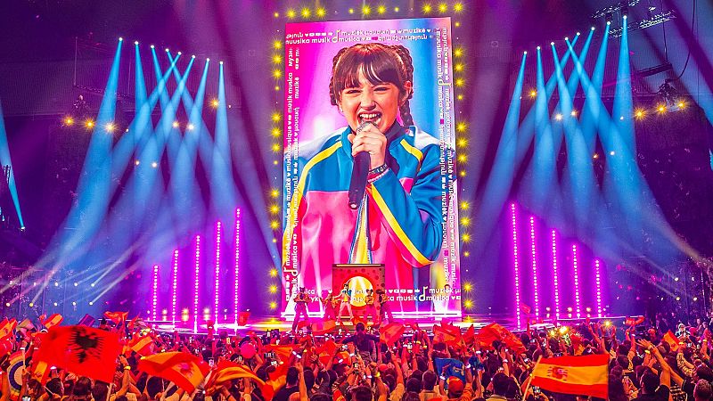 Chloe de la Rosa en el escenario de Eurovisión Junior 2024, con el público ondeando banderas.