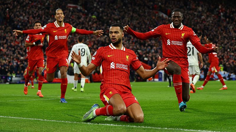 Celebración de jugadores del Liverpool tras un gol en partido contra el Real Madrid. Un jugador arrodillado, otros corriendo, dorsal 9 visible.