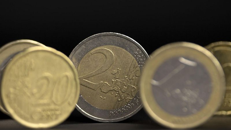 Monedas de euro (20 céntimos y 2 euros) sobre fondo negro. Ilustración para noticia sobre aumento del déficit público en España.