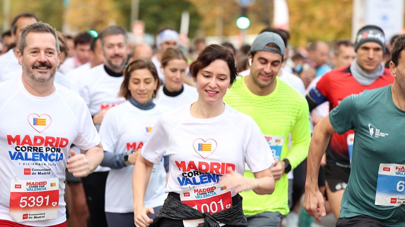 Isabel Díaz Ayuso corriendo en la carrera "Madrid Corre por Valencia", con camiseta blanca y dorsal.  Imagen relacionada con noticia sobre una supuesta "operación de Estado".
