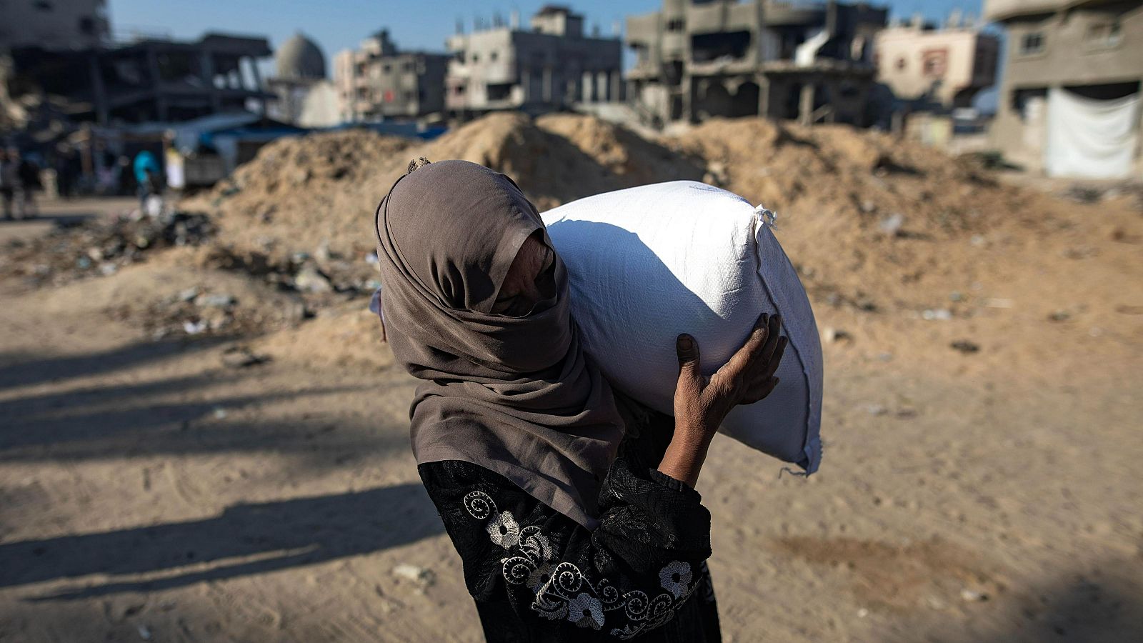 Una mujer palestina lleva ayuda recogida en un centro de la ONU en Khan Younis, en Gaza