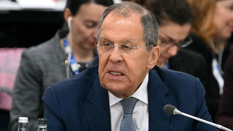 Sergei Lavrov, en traje azul marino y camisa blanca, habla ante un micrófono en una cumbre.  Otras personas están presentes en segundo plano.