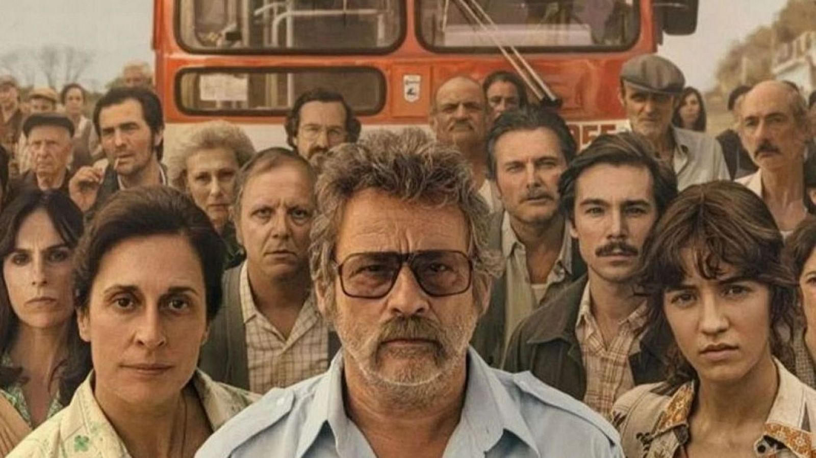 Grupo de personas frente a un autobús rojo de dos pisos, en una escena que evoca los años 70 u 80.  Imagen promocional de la película 'El 47'.