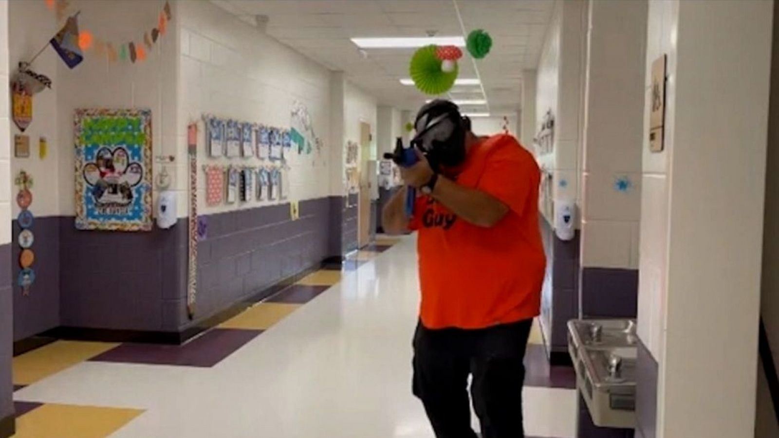 Hombre armado en pasillo de colegio