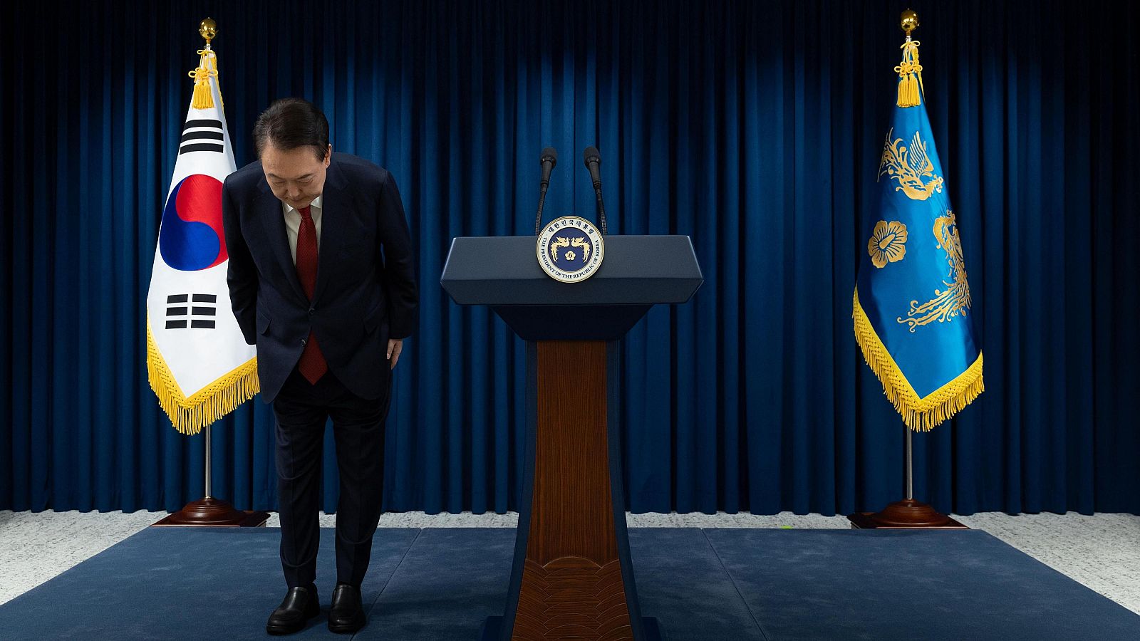 El presidente Yoon Suk Yeol haciendo una reverencia durante su discurso a la nación.