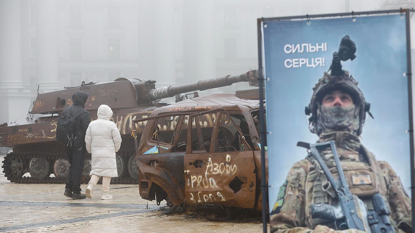 Varias personas caminan junto a maquinaria militar rusa destruida y vehículos civiles ucranianos dañados expuestos cerca de la catedral de San Mykhailivsky en el centro de Kiev