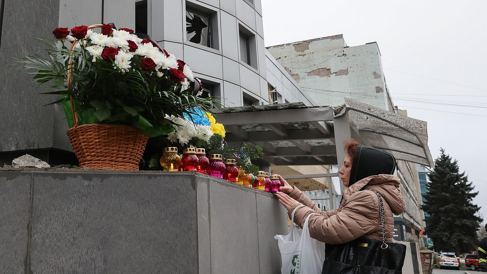 Una mujer ucraniana llevan flores cerca del lugar donde se produjo el impacto de un cohete contra una clínica privada en Zaporizhzhia, sureste de Ucrania, el 11 de diciembre de 2024