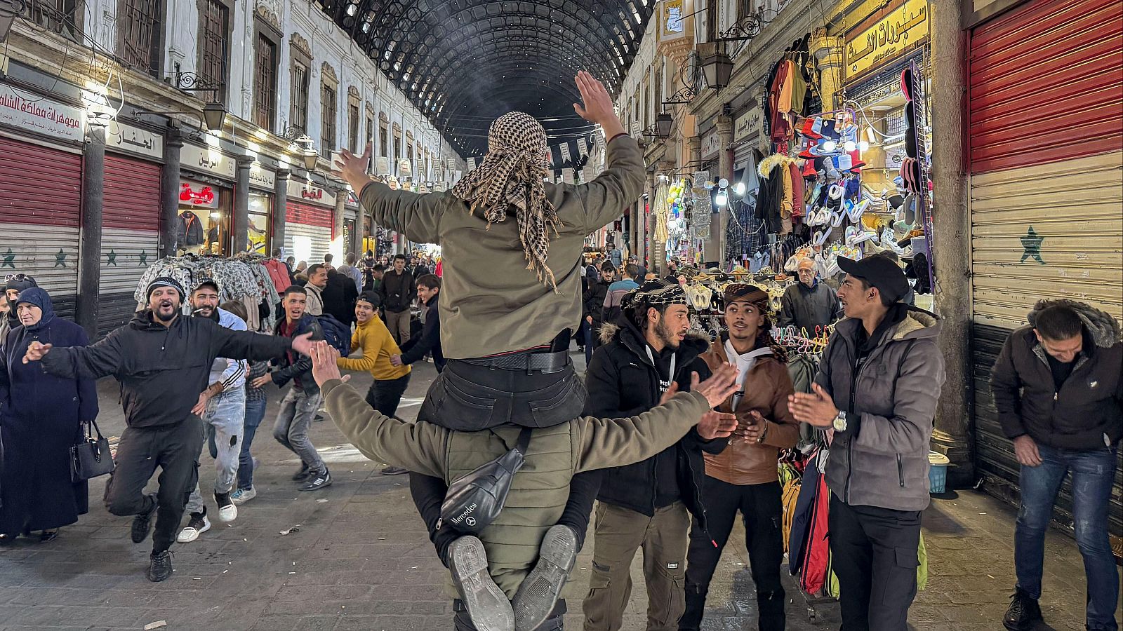 Personas bailan y dan muestras de alegría en el zoco de Al Hamidiya, en Damasco