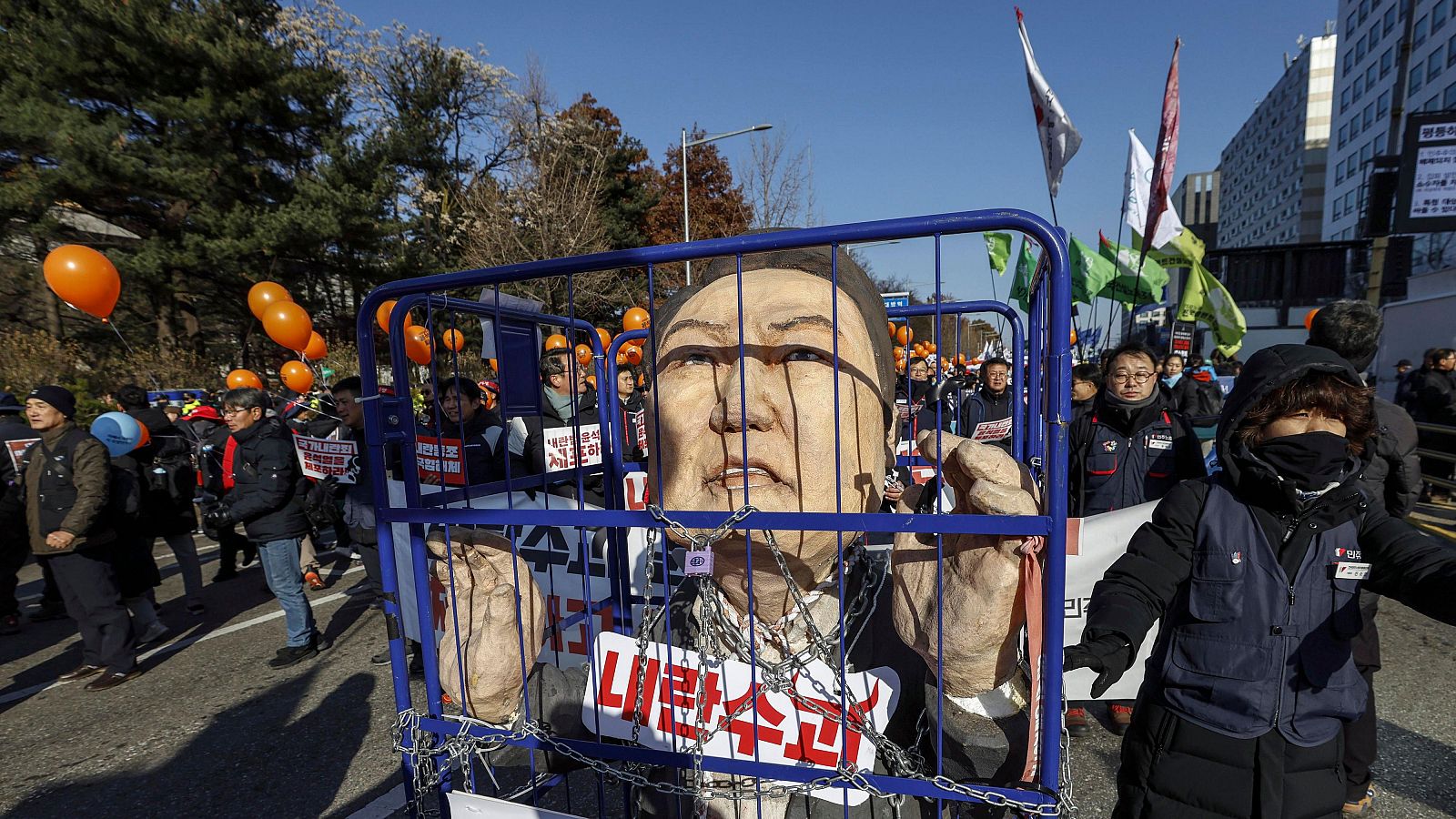 Manifestantes portan una efigie del presidente surcoreano Yoon Suk-yeol durante una concentración para pedir su destitución