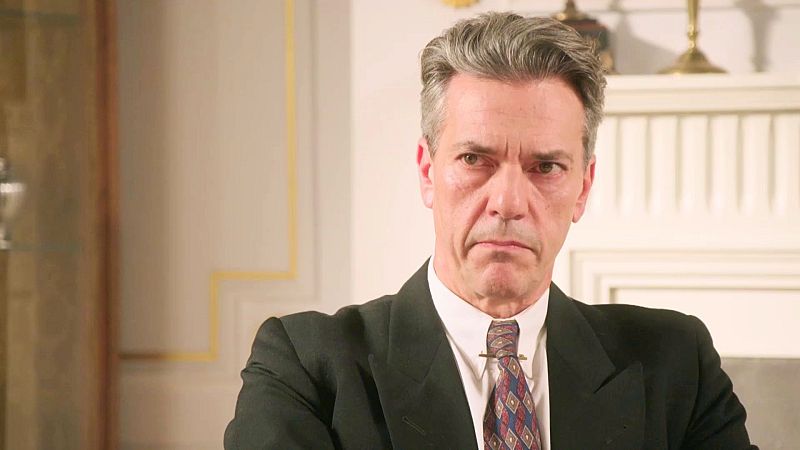 Hombre en traje oscuro con expresión seria en habitación elegante.  Titular sugiere conflicto con alguien llamado César.