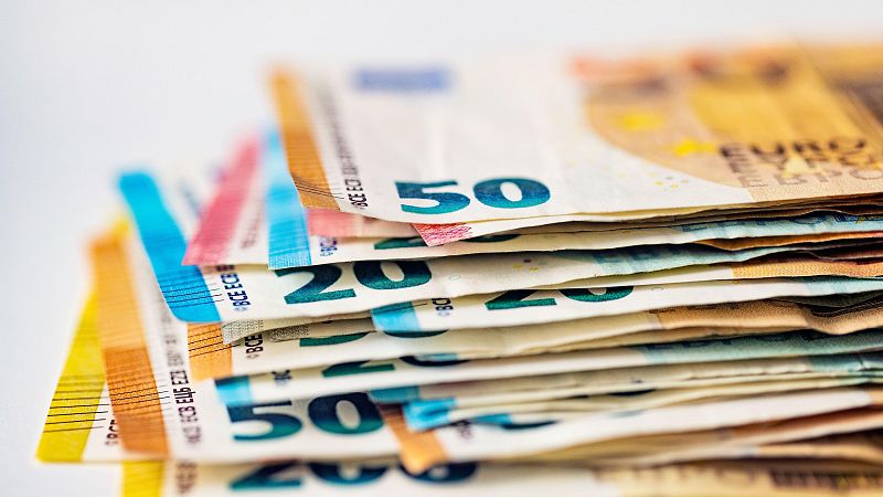 Billetes de 20 y 50 euros apilados, mostrando una mejora en las finanzas públicas. Ilustración visual de la disminución del déficit.