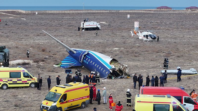 Avion comercial accidentado cerca de la costa.  Daños severos en la parte delantera.  Presentes vehículos de emergencia y personal de rescate.