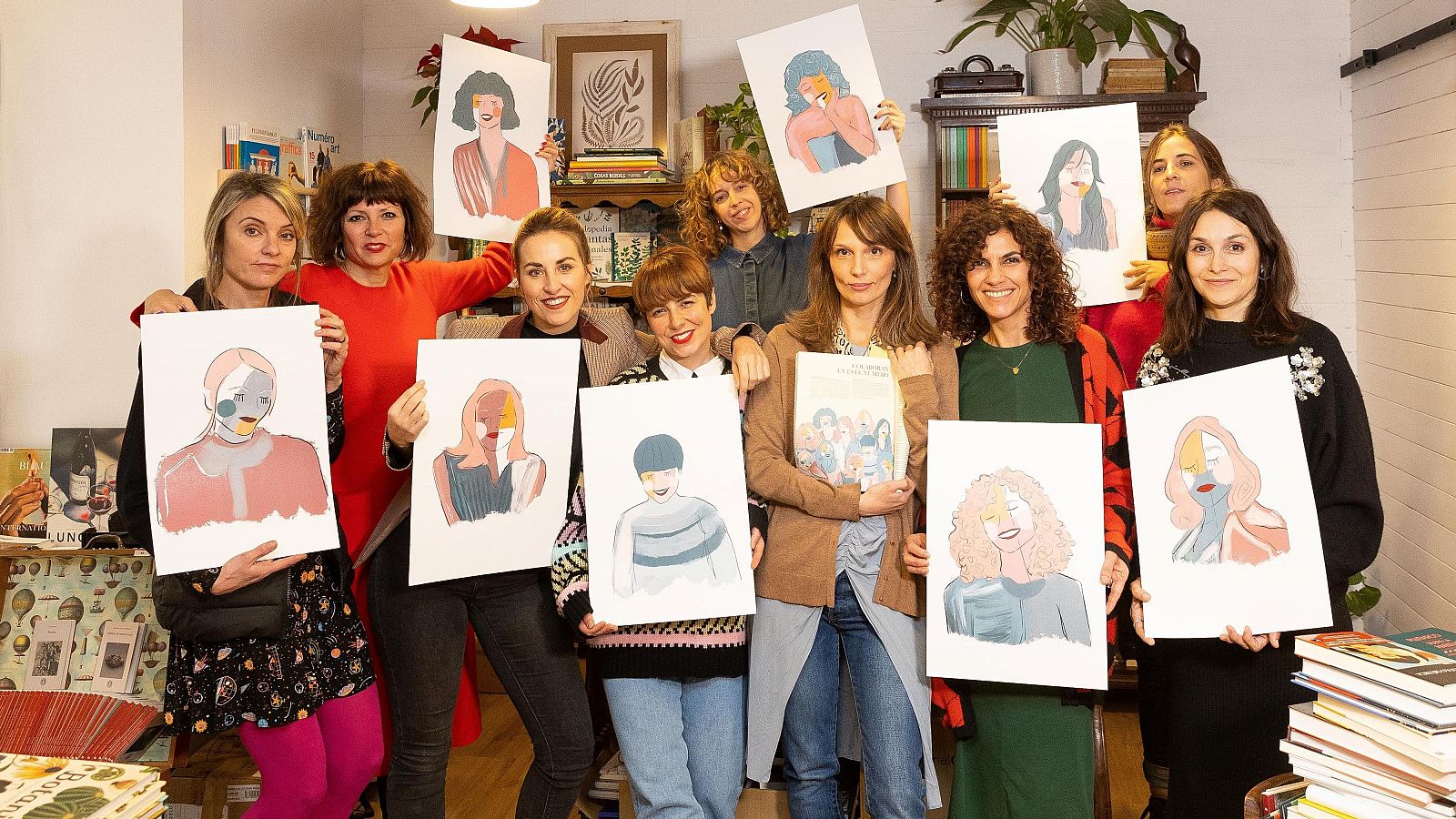 Diez mujeres, vestidas de forma variada, sostienen láminas con retratos artísticos femeninos en colores pastel.  Imagen de equipo en espacio interior con estanterías.