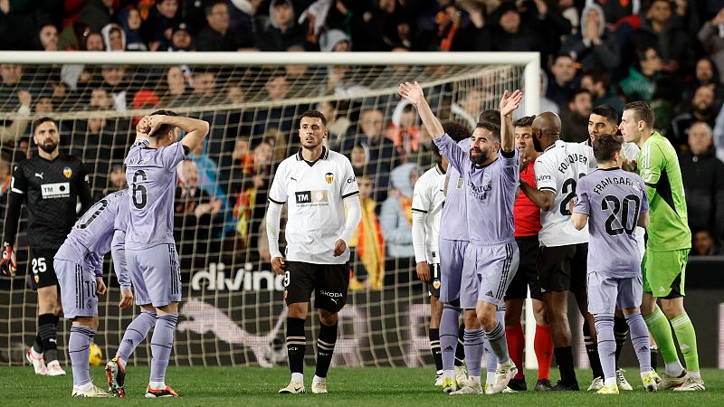 Final de partido de fútbol: jugadores del Real Madrid (camisetas moradas) celebran, mientras jugadores del Valencia (camisetas blancas) muestran decepción.  Se ven dorsales 9, 20 y 25.