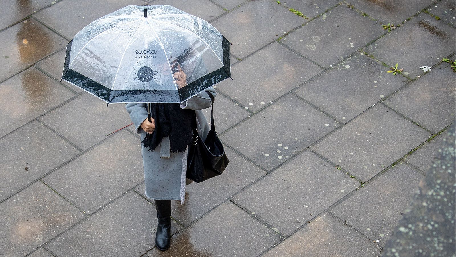 Una mujer se protege de la lluvia en Logroño