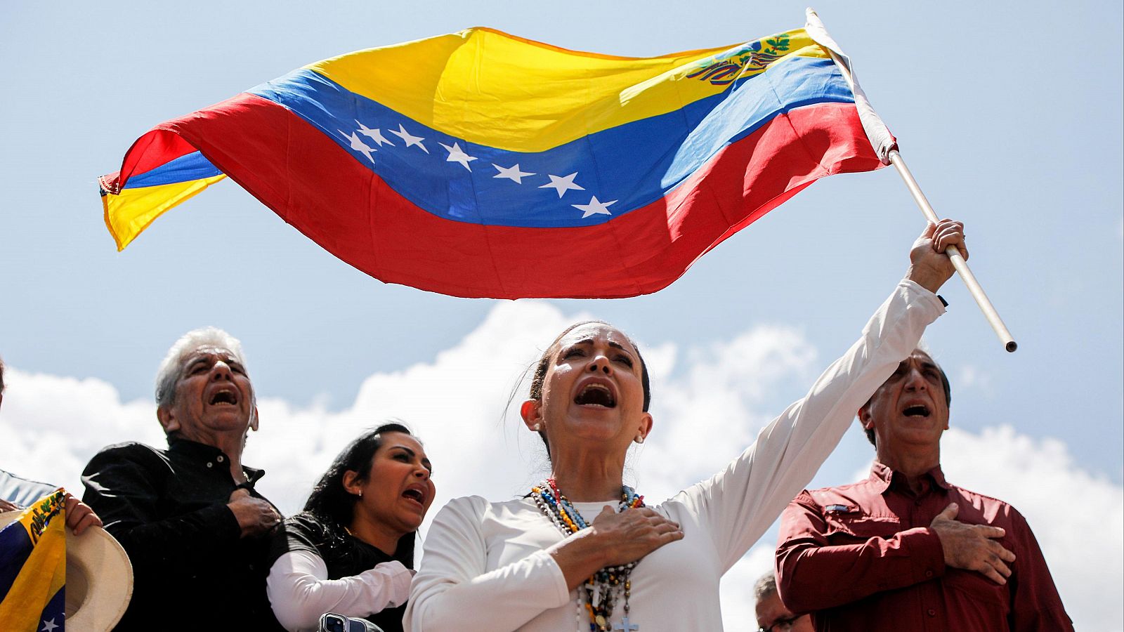 La líder opositora venezolana María Corina Machado ondea una bandera durante una manifestación en Caracas