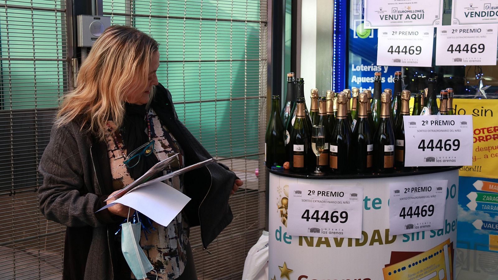 Treballadora de l'adminstració de loteria del centre comercial Arenas de Barcelona preparant ampolles de cava per celebrar el segon premi repartit del sorteig de Reis del 2022. (ACN | Albert Cadanet)