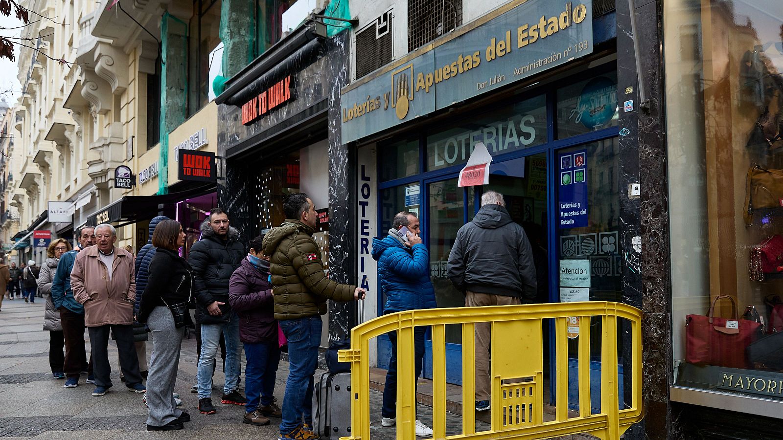 Un grupo de personas, haciendo cola en una Administración de Lotería