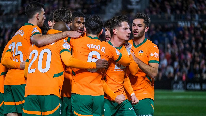 Celebración eufórica de jugadores del Valencia CF tras marcar un gol, mostrando dorsales como el 9, 15 y 20.  Emoción tras el tanto de la victoria en partido de Copa del Rey.