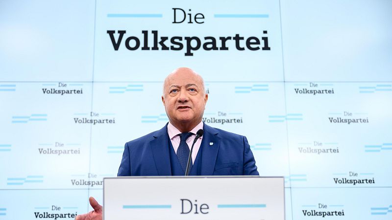 Rueda de prensa de un líder político austriaco frente a un atril, con el logo de su partido visible en el fondo.  Parece realizar una declaración oficial.