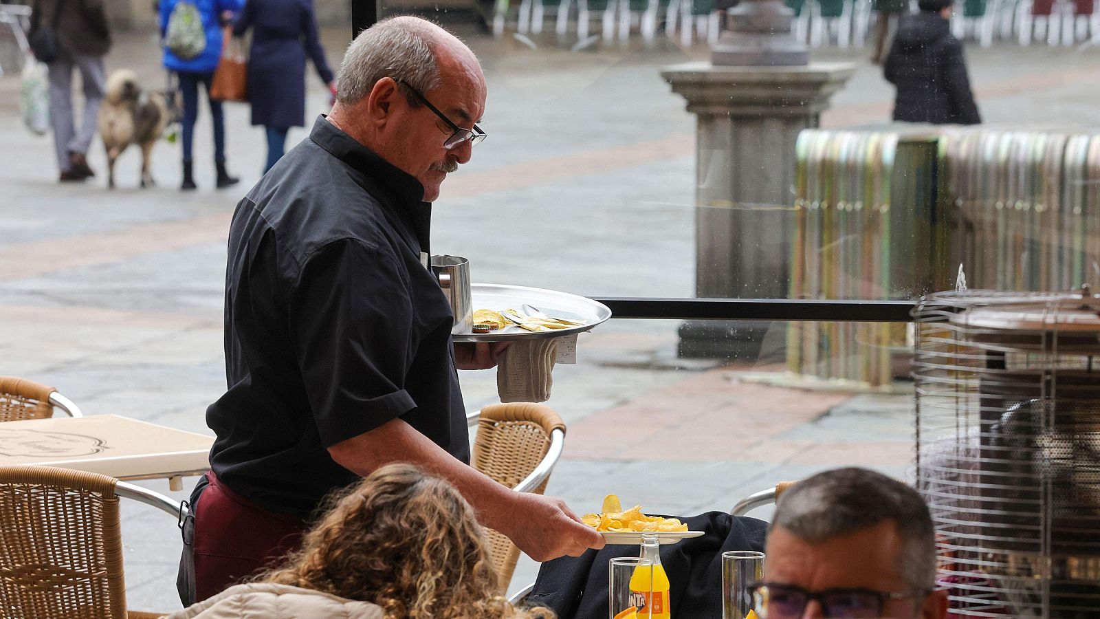 Un camarero trabaja en la terraza de un local de restauración en Salamanca