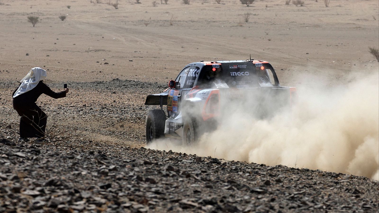 Un espectador toma una imagen al paso de un coche en una etapa del Dakar 2025