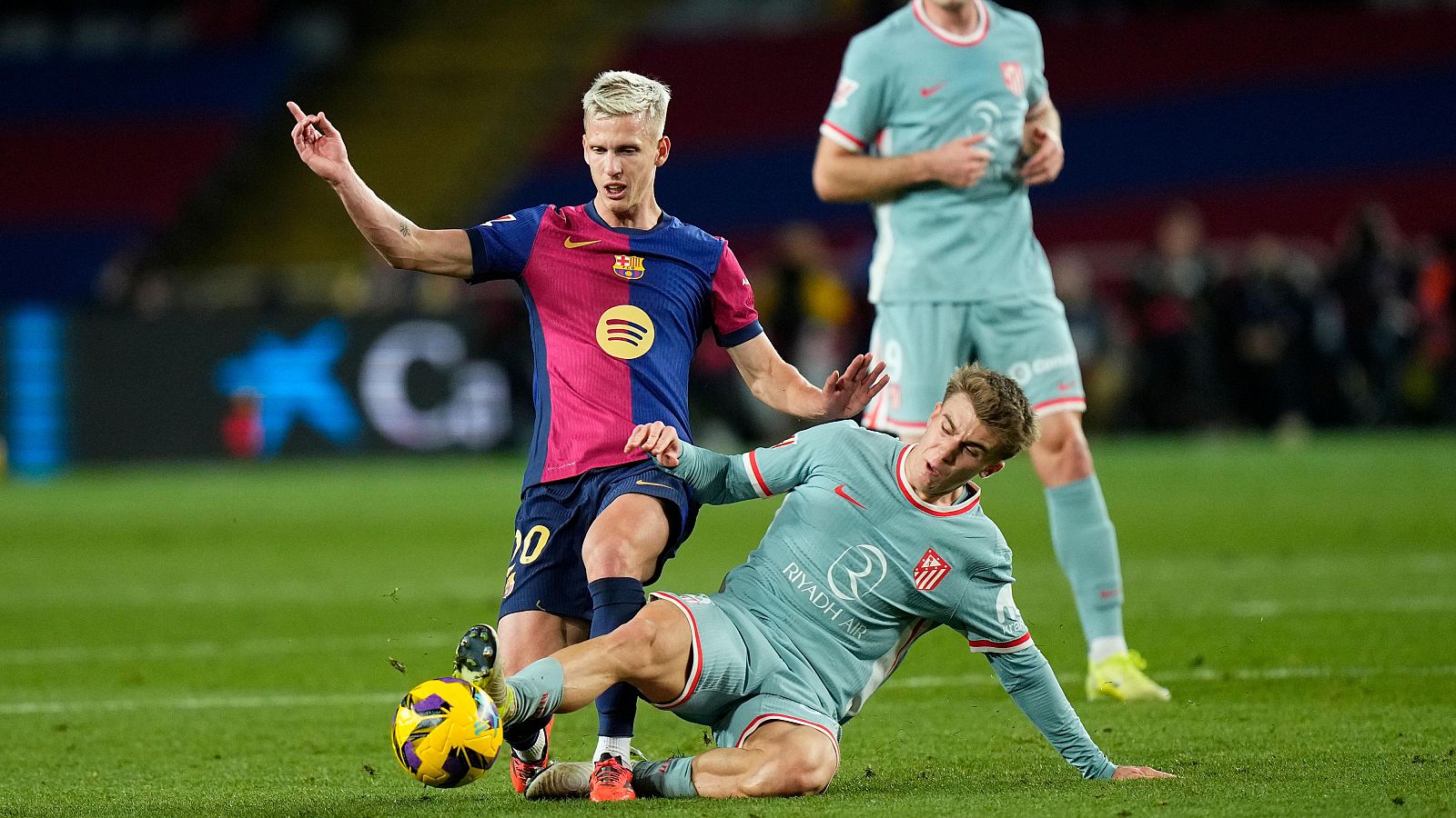 El jugador del FC Barcelona Dani Olmo (i) lucha con Pablo Barrios, del Atlético de Madrid, durante el partido de la jornada 18 de LaLiga en el estadio olímpico Lluis Companys.